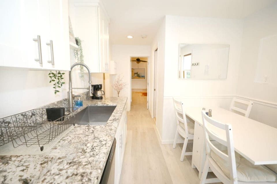 Bright and fully stocked kitchen. Everything you need from pots and pans, to appliances, dishware and more and.  Gas stove with oven, dishwasher, full size refrigerator and cozy dining table.