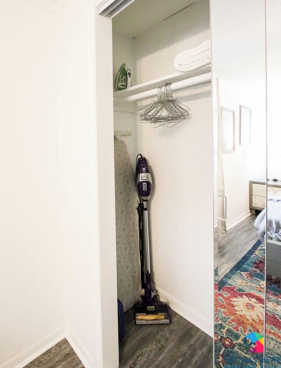 Vacuum, iron, ironing board in closet