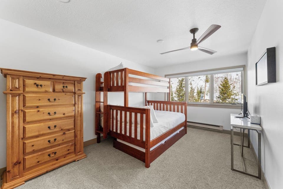 Guest bedroom with a TV and twin-over-queen bunk bed with twin trundle.