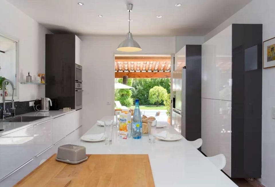 Fully equipped modern kitchen with central island opening onto dining terra