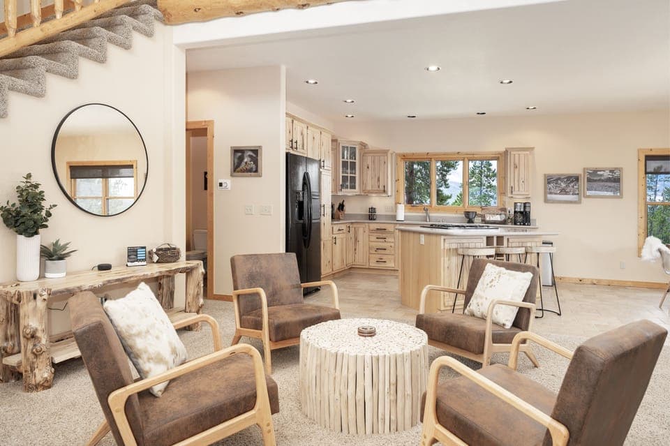 - Gather in this cozy sitting area with rustic wood accents and warm tones   - Open layout connects the living space seamlessly to the kitchen and dining   - Relax in comfortable armchairs that make conversation easy and inviting