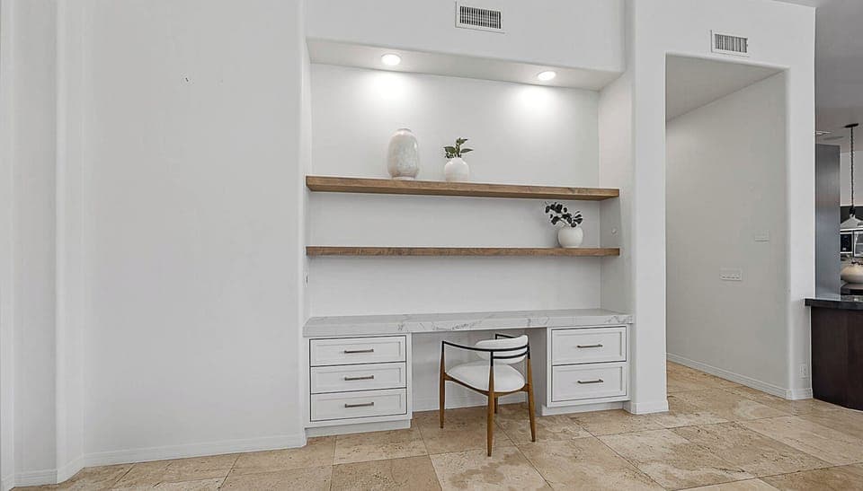 Work desk with shelves near kitchen & living room for a convenient workspace.