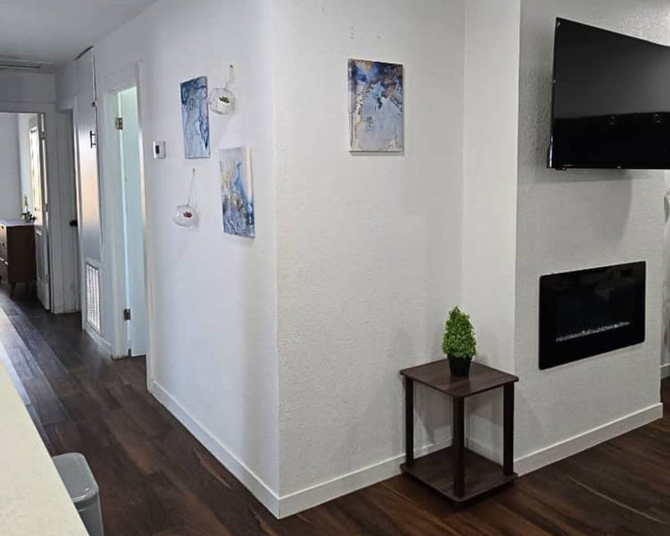 Bright hallway with wall decor, mounted TV, and modern charm.