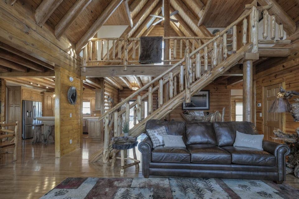 Great Hearth Room staircase and mantle feature real logs harvested from property