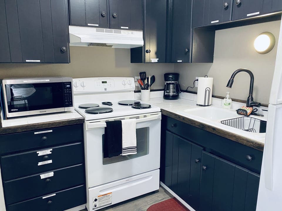 Kitchen with stove/oven, microwave, coffee pot, fridge 