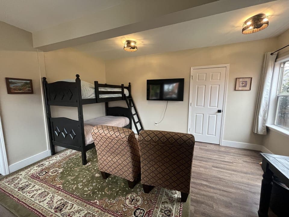 Adjoining room in downstairs of carriage house with bunk beds and TV