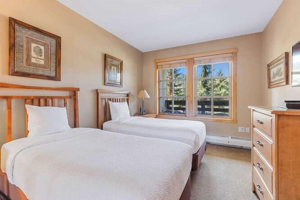Twin bed room offers a lot of natural light from windows.