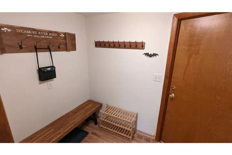mud room with plenty of hooks for jackets, multiple shoe racks, and binoculars