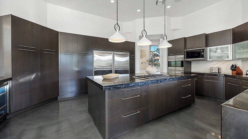 Beautiful kitchen with double oven, island cooktop & oversized fridge.