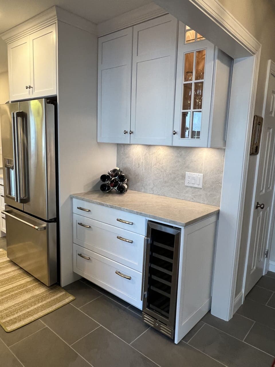 Full bar station with glass ware and mixology tools.  Wine cooler and rack.