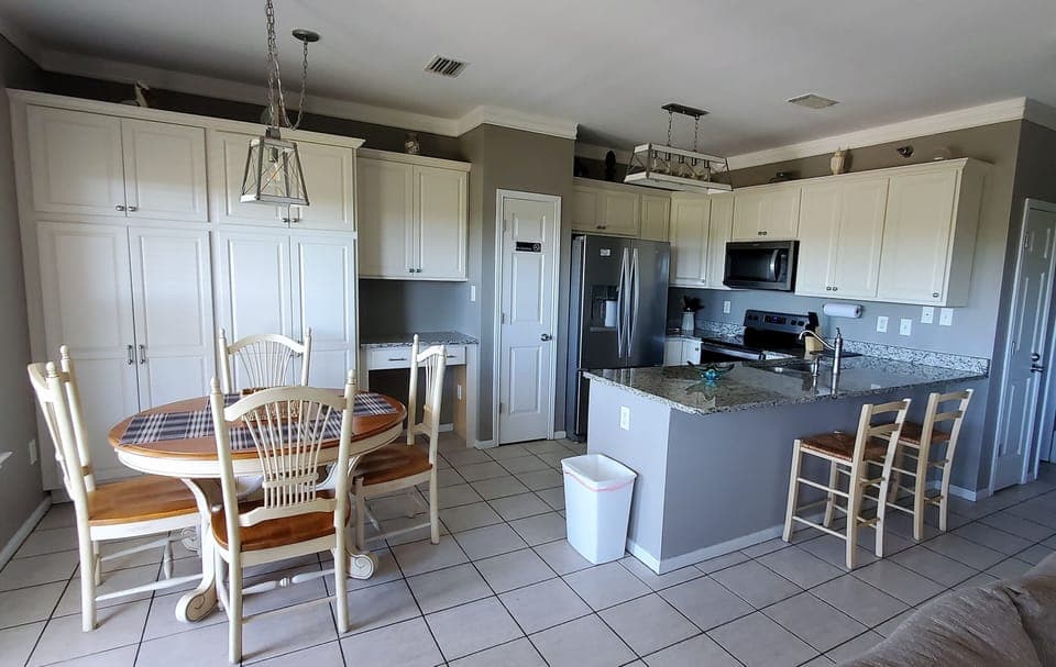 Dining area and kitchen. Large storage cabinets and desk occupy back wall.