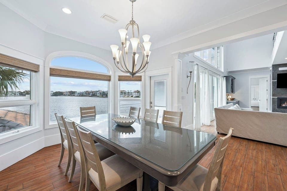 Gather around this elegant dining table with stunning water views streaming through arched windows, creating the perfect backdrop for memorable meals.