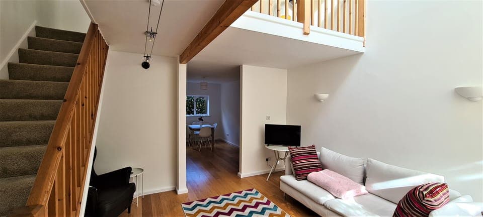 Downstairs, showing living room stairs and balcony.