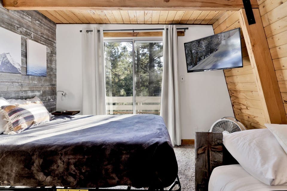 Peaceful cabin bedroom with plush bedding, and beautiful views—ideal for restful nights, cozy mornings, and a relaxing mountain escape.