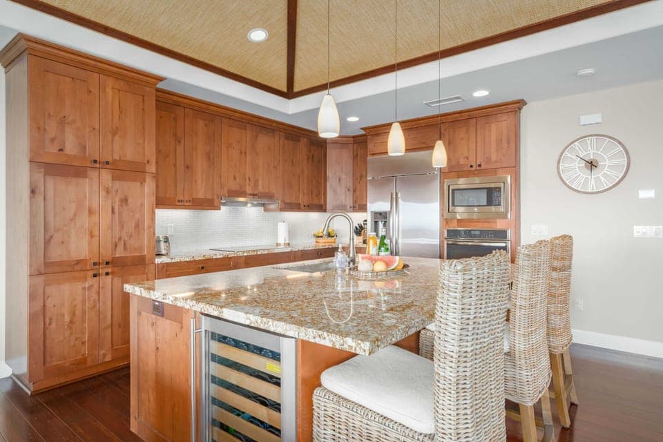 Large fully equipped kitchen, with stainless steel appliances including wine cooler, microwave, oven, electric cook-top, range hood and dishwasher.