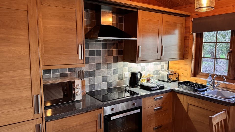 Kitchen with fridge with freezer compartment, oven, hob, microwave, kettle and toaster