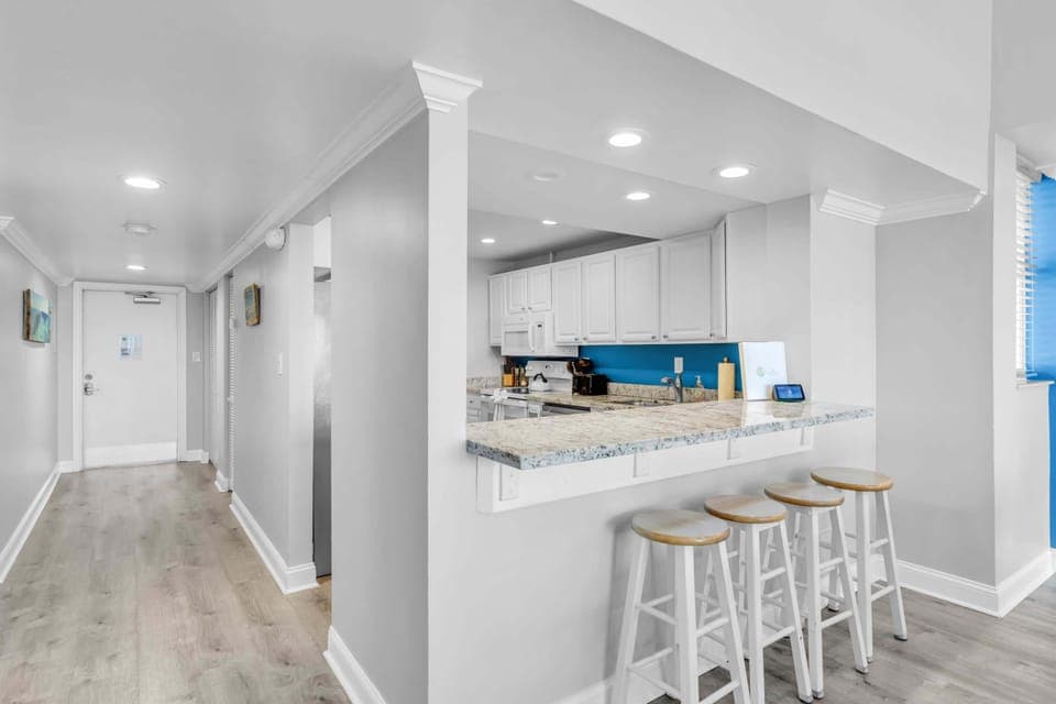 Updated kitchen with granite countertops and cooking supplies