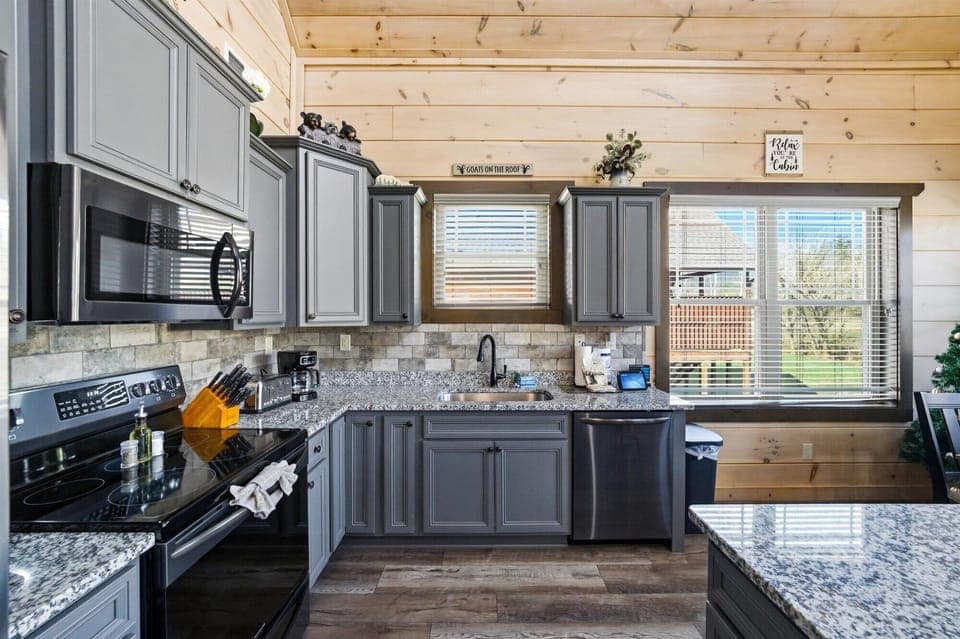 Prepare delicious meals in your fully equipped kitchen featuring granite counters, stainless appliances, and natural wood accents.