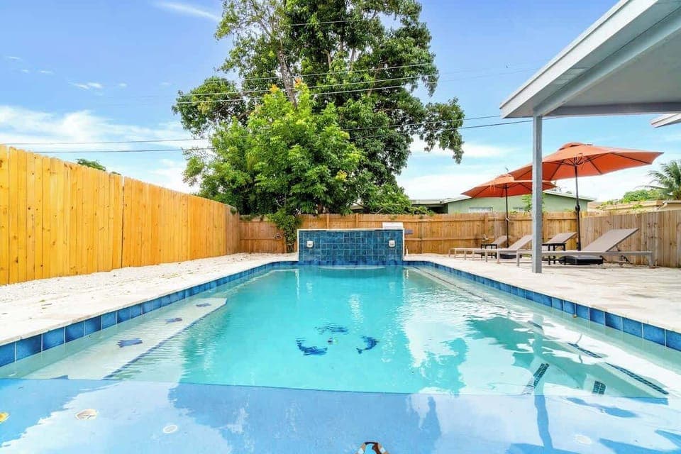 "Dive into comfort! This inviting Airbnb features a waterfall pool, shaded seating, and peaceful backyard charm—your perfect vacation retreat."
