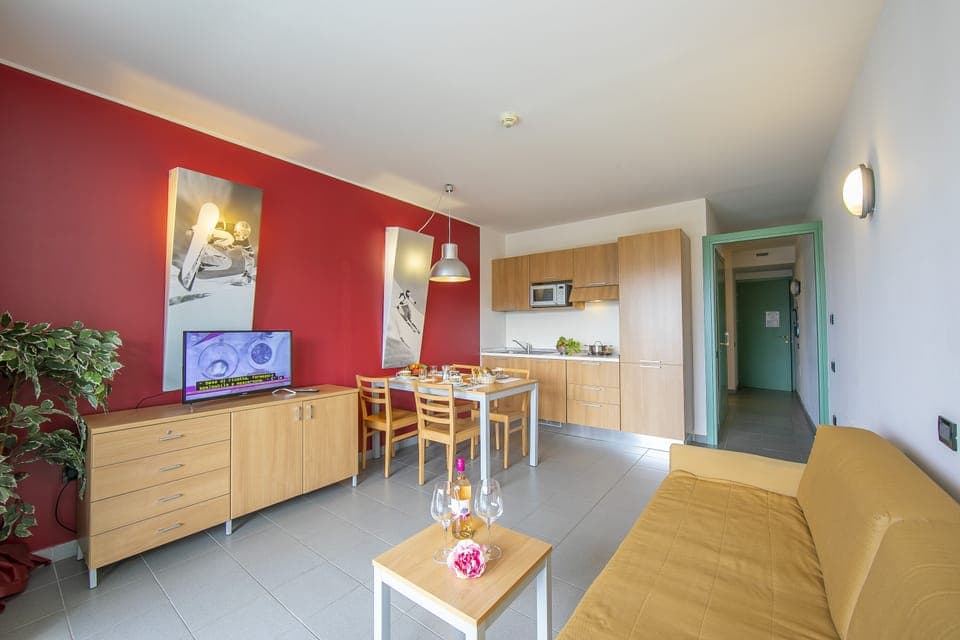 living area with sofa bed and view of kitchen and corridor