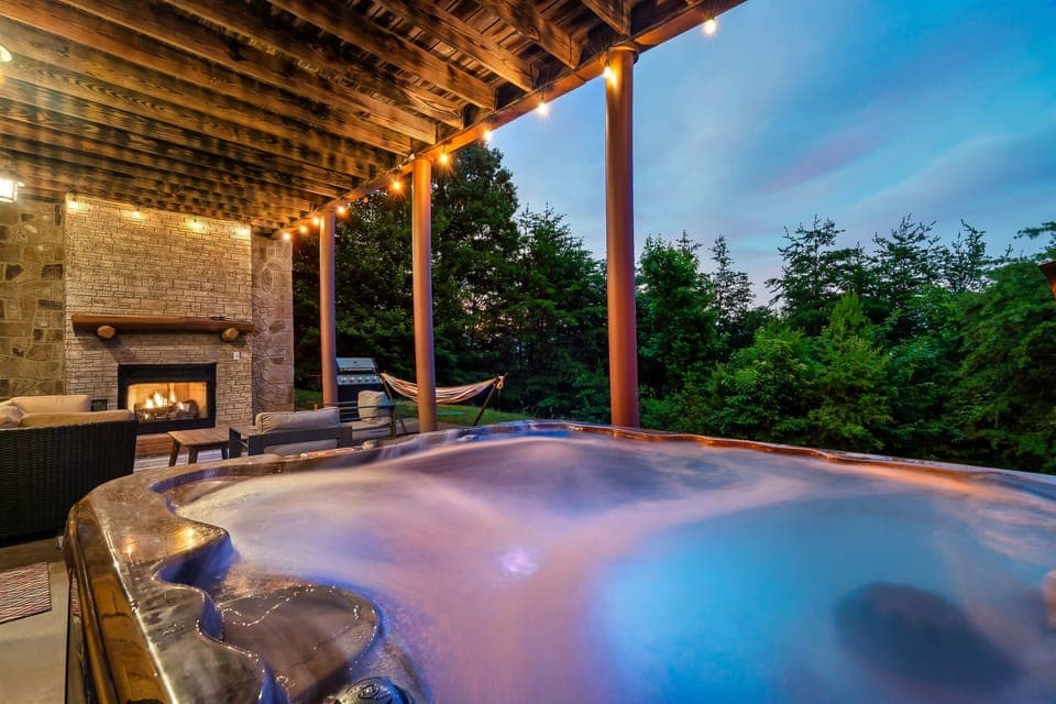 Unwind in your private hot tub under twinkling lights, cozy up by the outdoor fireplace, or relax in the hammock surrounded by lush greenery