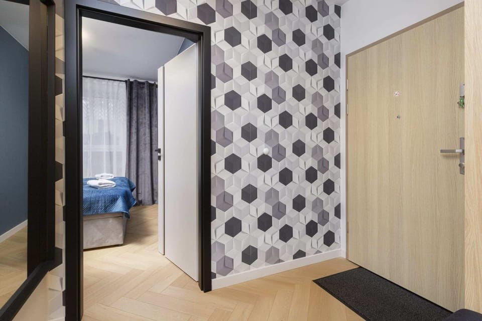 A view of an entryway or hallway featuring a bold polka-dot pattern on the walls and a wooden door.