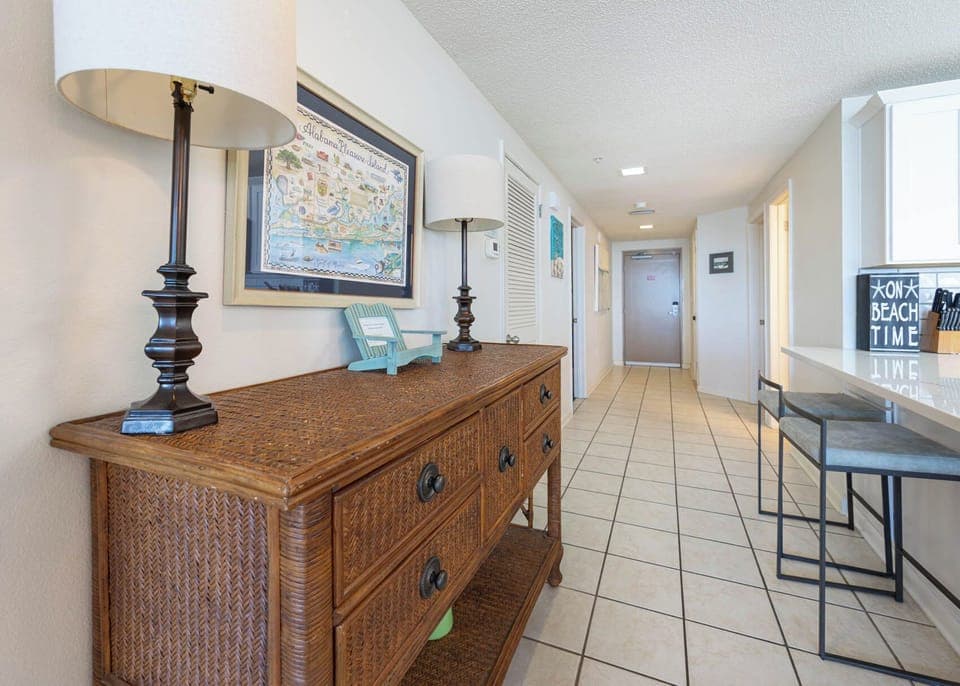 Step into a welcoming entryway featuring a stylish console table, decorative lamps, and a vibrant coastal map