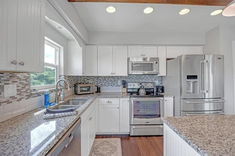 - Bright and clean kitchen offers extra counter space and quality appliances
- Glass tile backsplash and modern lighting highlight the chef ready setup
- All the essentials are here for morning coffee or full holiday feasts