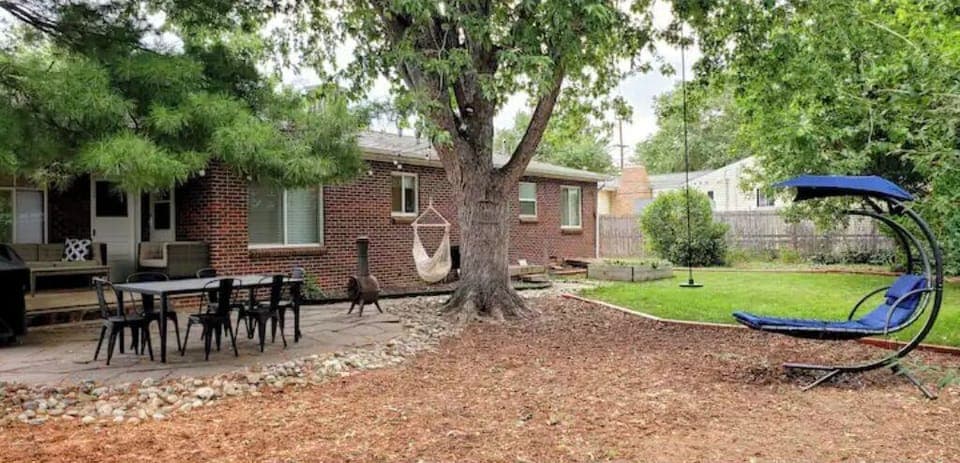 Spacious private backyard with plenty of seating, swings and a hammock chair. 