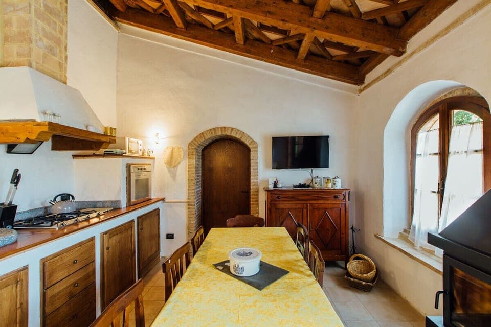 zona giorno con caminetto, divano letto e cucina attrezzatissima