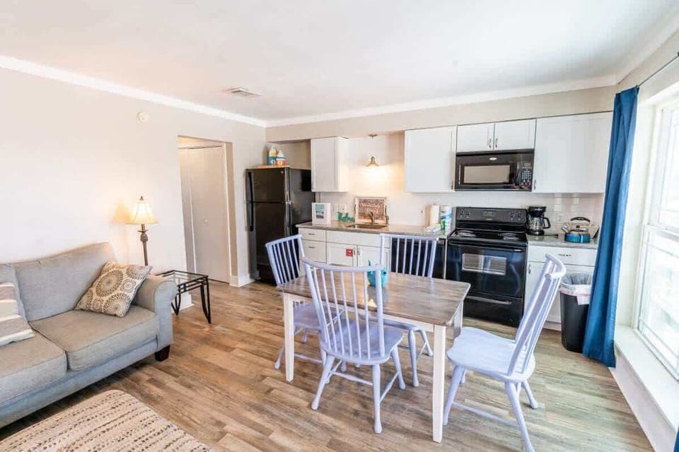 Living room with Dining room table. Full kitchen with a view. Microwave, Refrigerator and Freezer. Washing machine and Dryer. Trash can, and coffee pot.