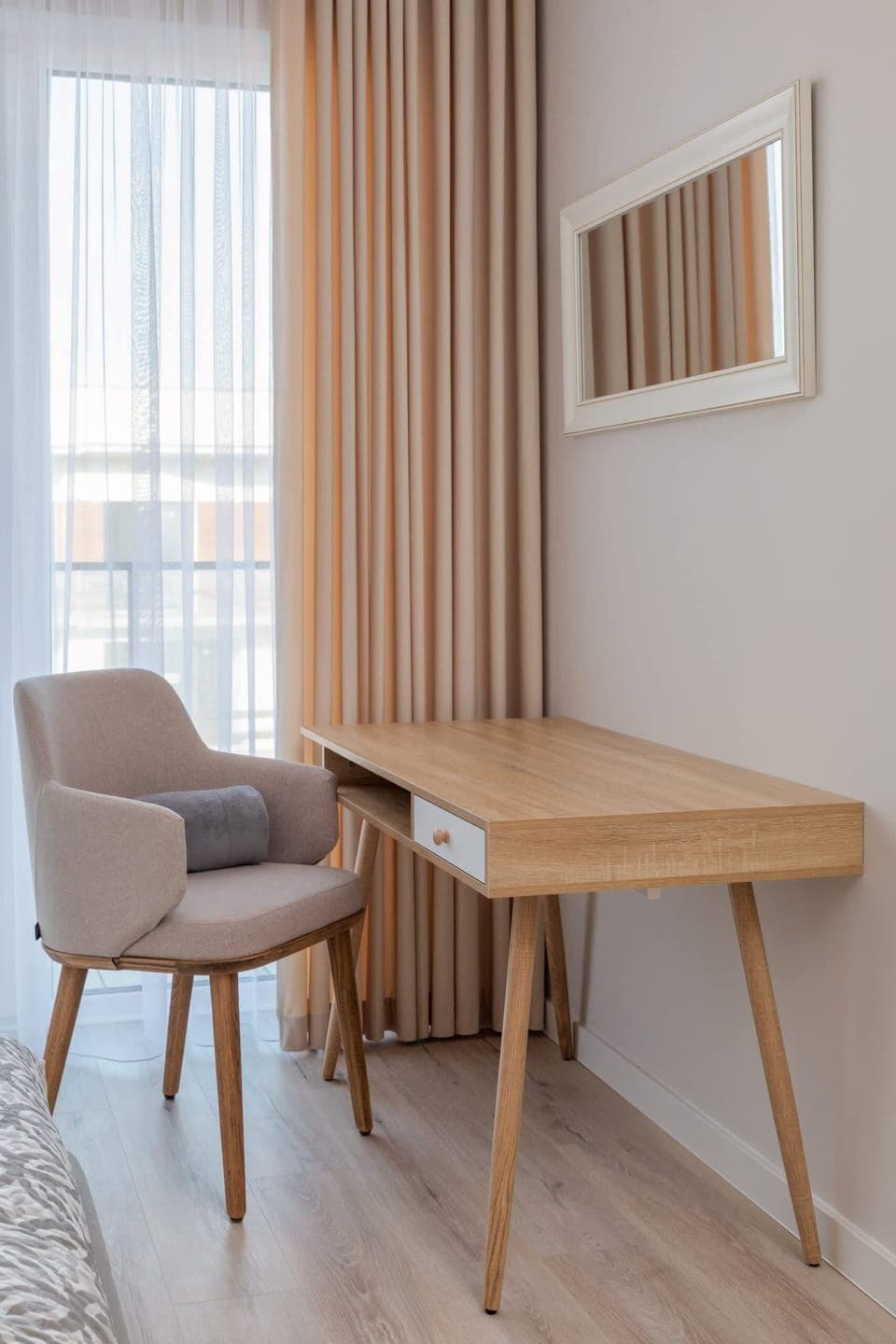 A bright workspace with a sleek desk and chair next to a window for natural light.

