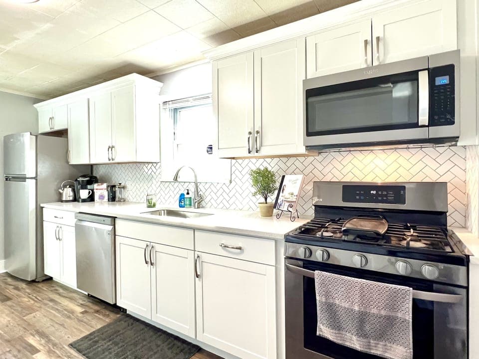 Newly updated kitchen with stainless appliances  and white quartz countertops.