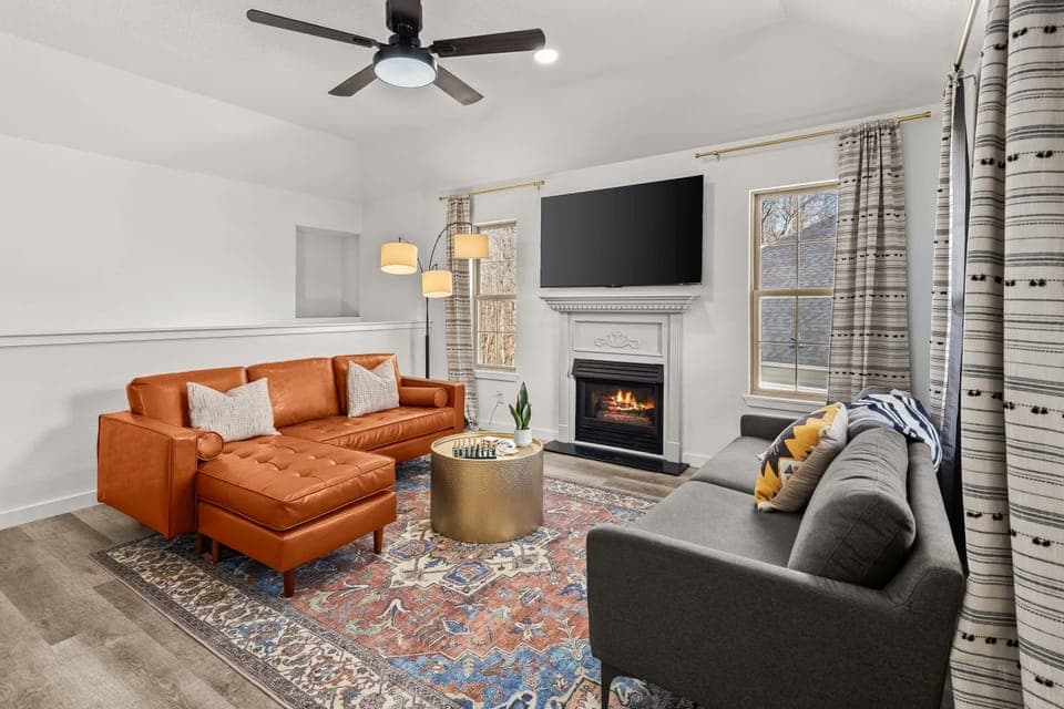 Light‑filled living room with plush leather sectional, smart TV & gas fireplace – relax after a day on the trails.