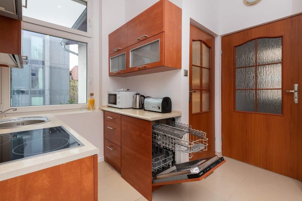 A fully equipped kitchen with wooden cabinetry and a modern stove.
