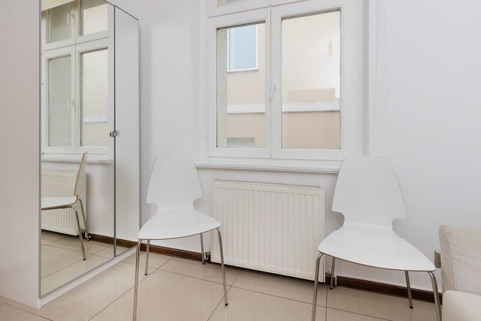 A modern chair and small side table positioned next to a window for natural light.
