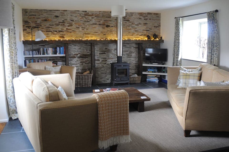 Cosy lounge, tastefully finished in natural fabrics, with log burning stove.