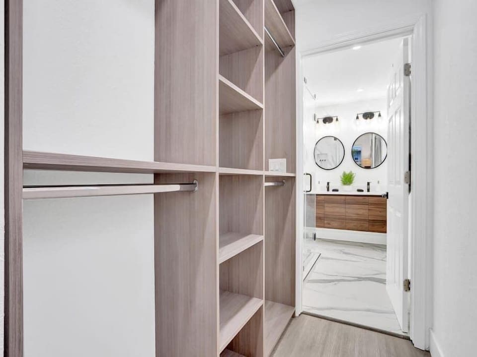 Closet in primary bedroom that leads into a gorgeous en suite bathroom