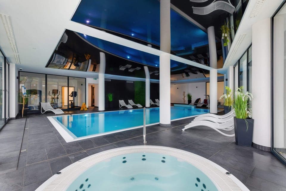 A luxurious indoor pool area with a hot tub, perfect for relaxation.
