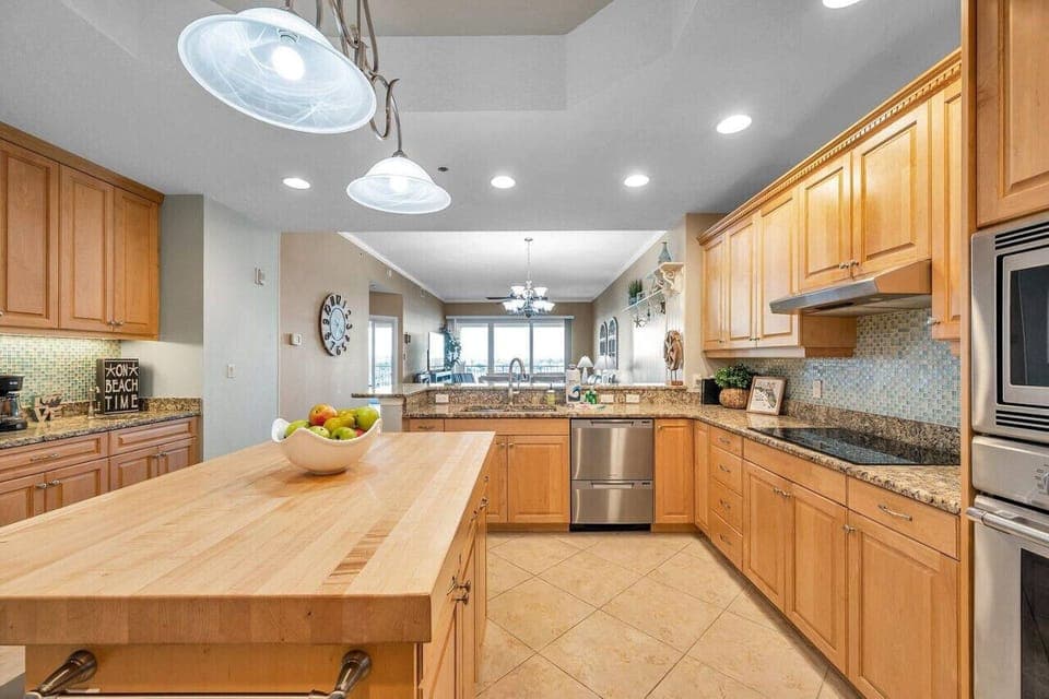 Spacious kitchen w/ wood cabinetry, stainless appliances, & a long island ideal for group cooking.