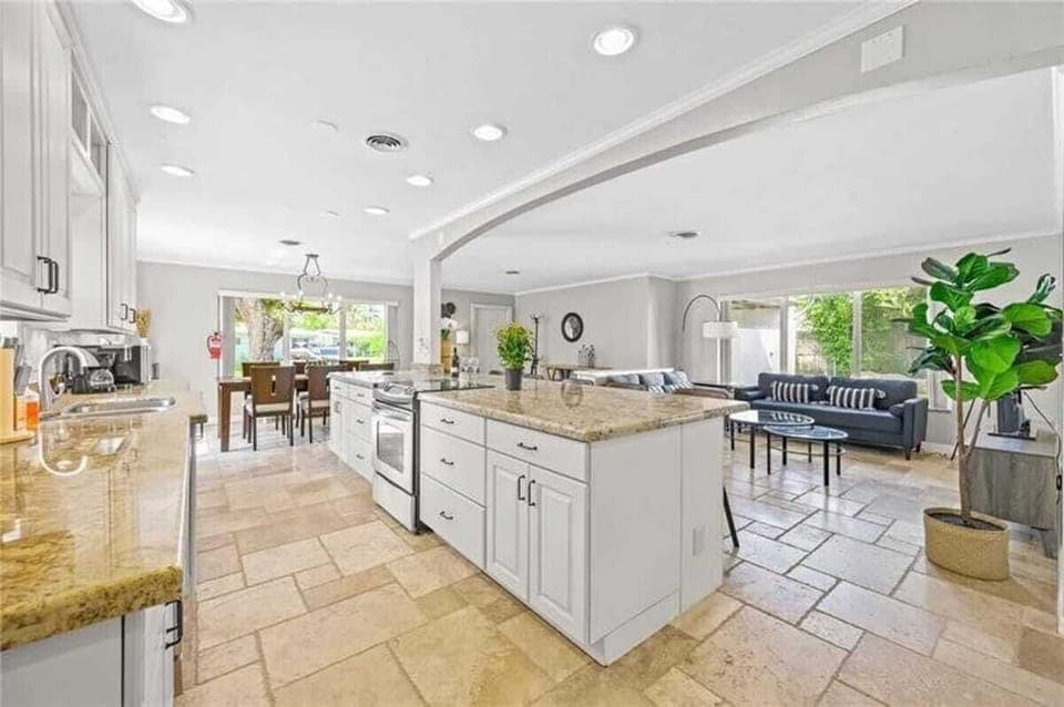 Open layout kitchen with island. Full set of appliances, including a Keurig coffee maker and basic kitchen utensils. 