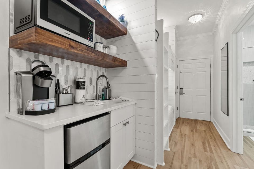 Kitchenette nook outfitted with fridge, microwave, and coffee essentials
