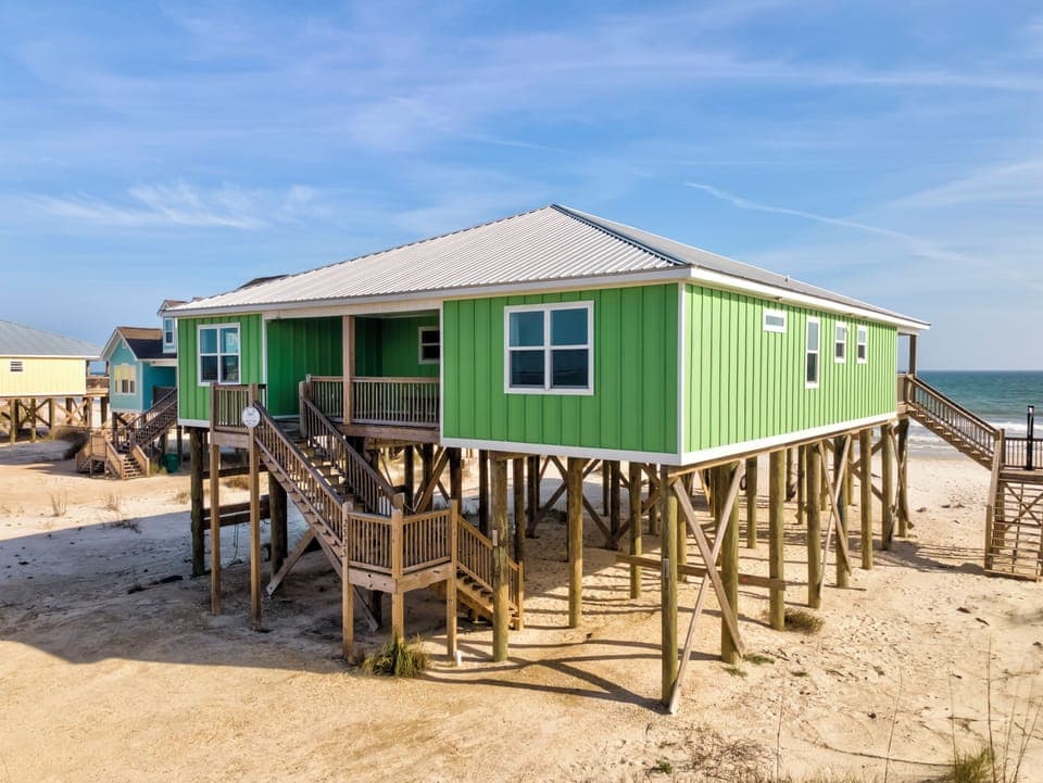 Charming beachfront cottage elevated on stilts with direct ocean access and sandy shores at your doorstep.