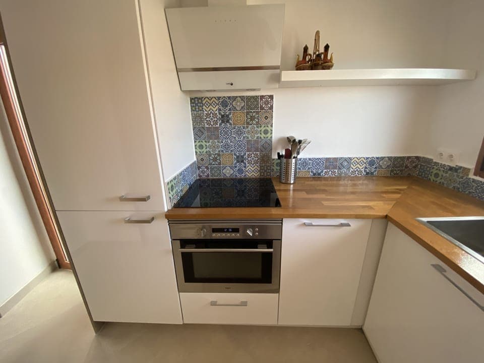 Well equipped kitchen with stove, oven and fridge with freezer