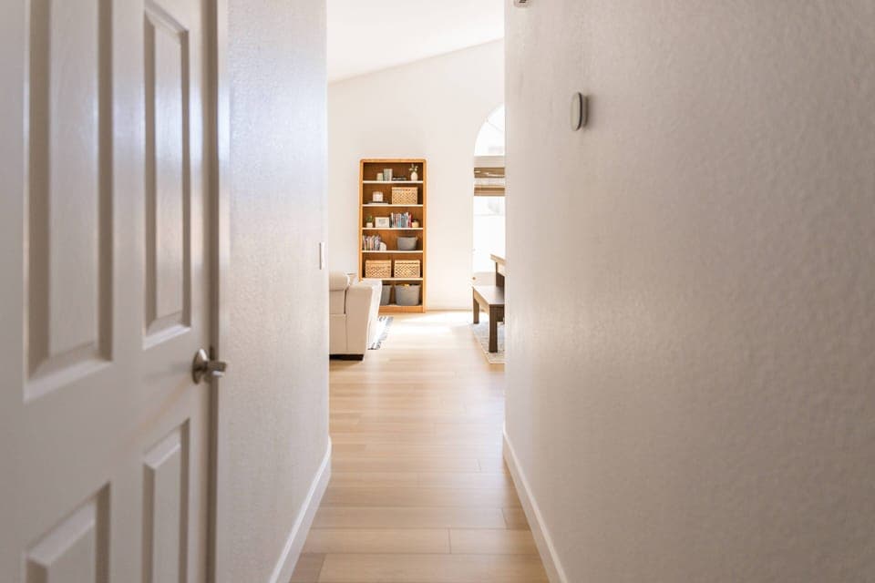 Hallway leads from bedrooms to front and dining room