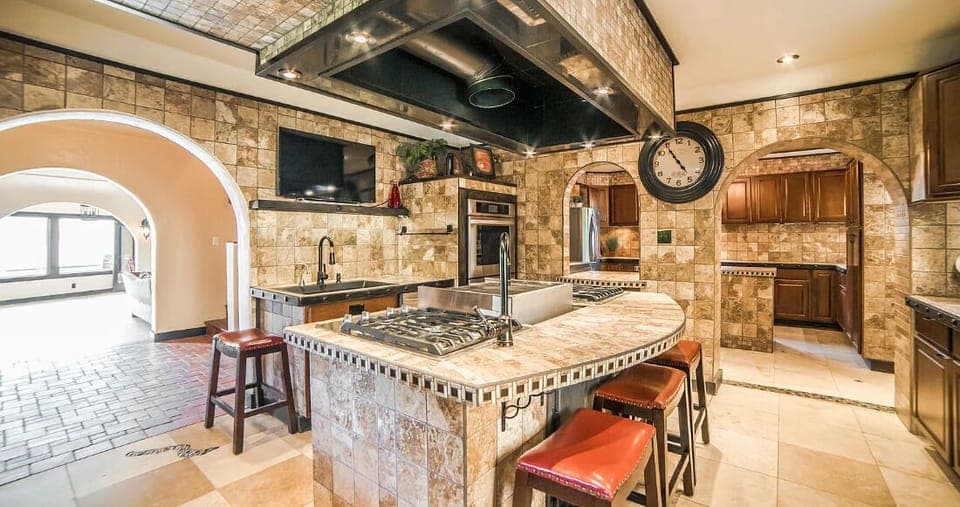 The Chef Kitchen's large island boasts 8 gas burners, a convenient pot filler, and indoor grill with gleaming countertops to an array of top-of-the-line appliances.