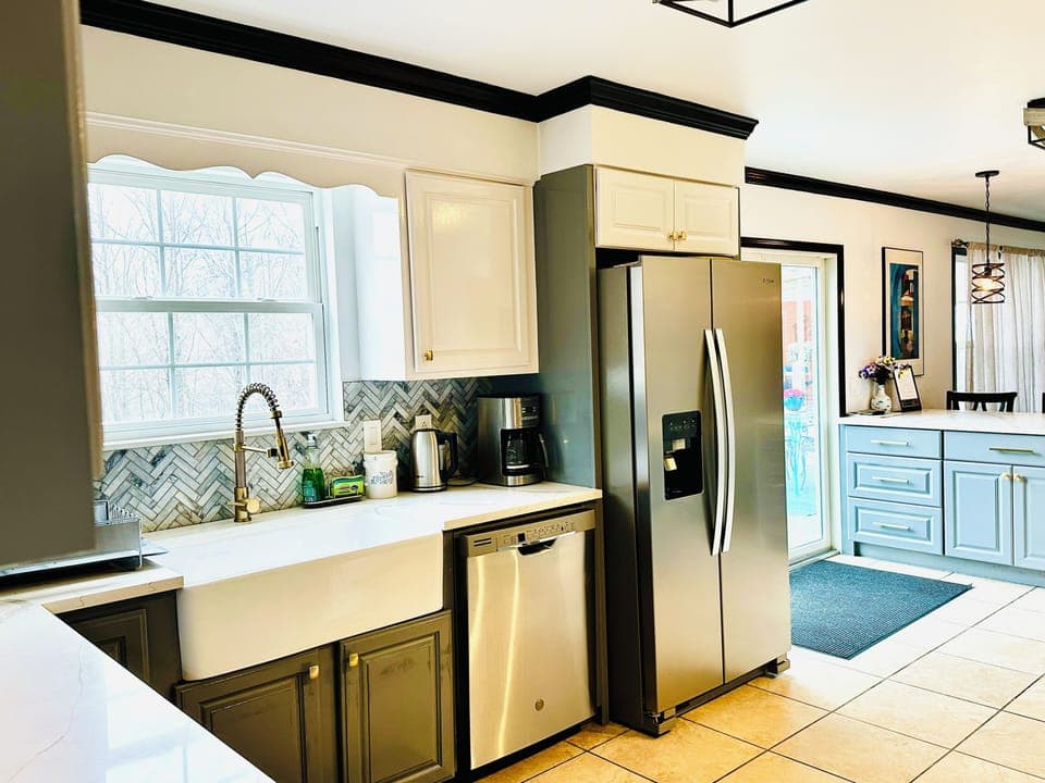 Full kitchen with a big fridge  and a large farmhouse sink 

