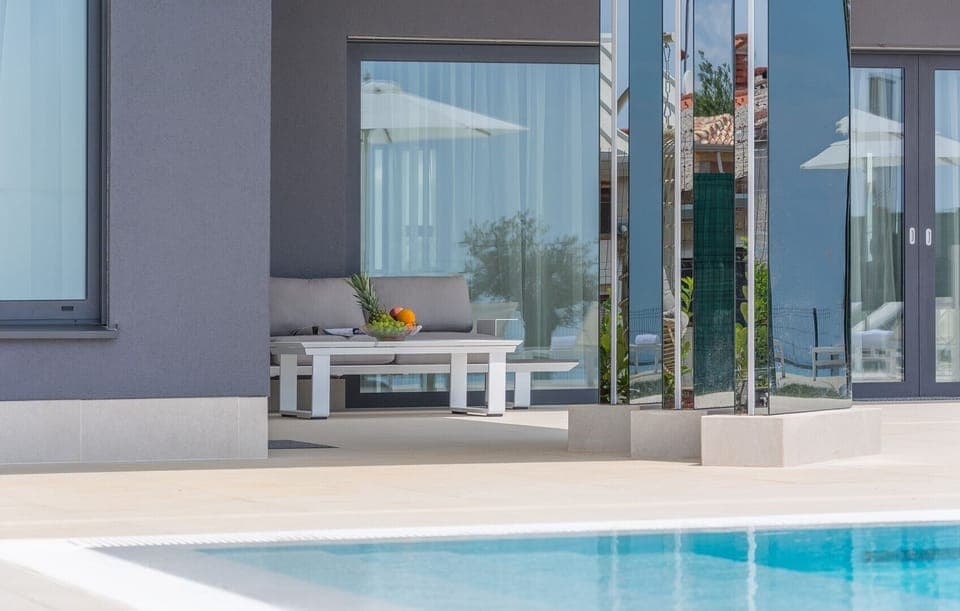 Seating set with a wooden table on the outdoor terrace of the luxury villa Nimai Luce in Istria