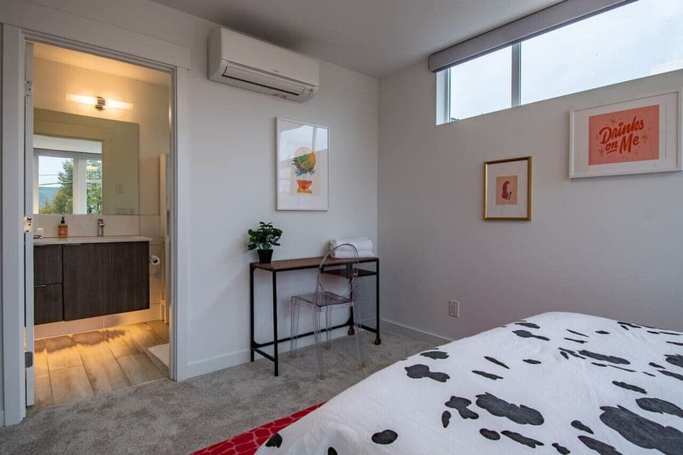 Another view of master bedroom, enjoy cow print duvet with clean and bright decor! Desk should someone need to work!
