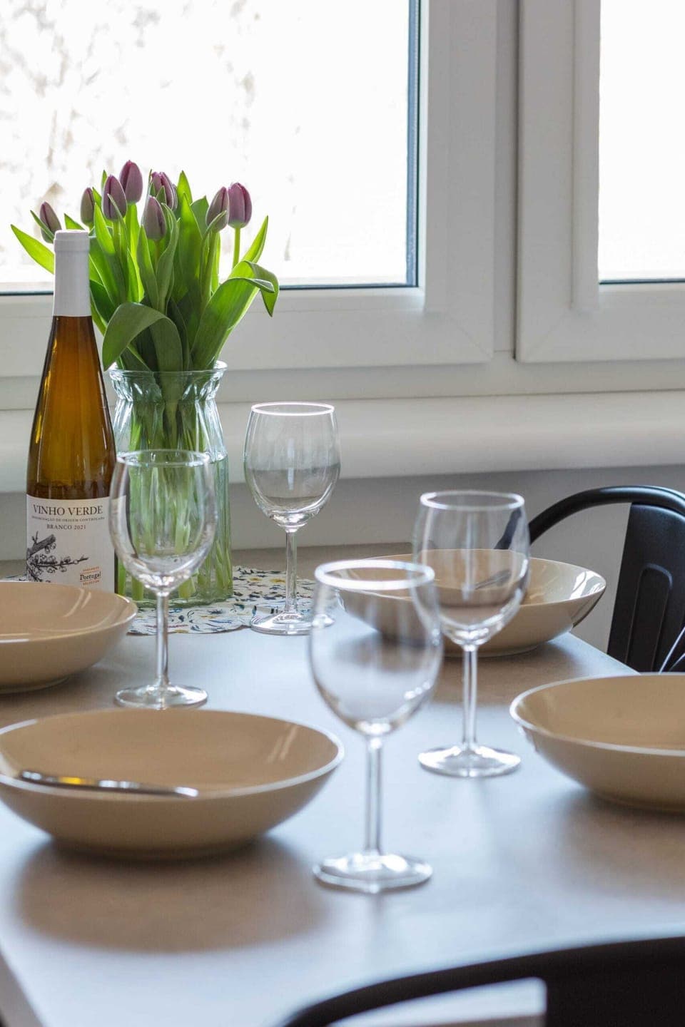 A modern dining table set with elegant tableware and fresh flowers, inviting for shared meals.